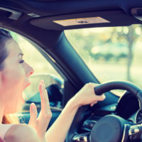 A woman yawning while driving A woman yawning while driving