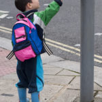 a little boy pushing crosswalk button a little boy pushing crosswalk button