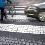 A guy pushing a stroller across the road A guy pushing a stroller across the road