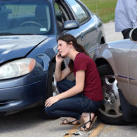 Lady that is on the phone trying to figure out who is liable for damages in a car crash pictured