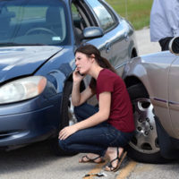 Lady that is on the phone trying to figure out who is liable for damages in a car crash pictured Lady that is on the phone trying to figure out who is liable for damages in a car crash pictured