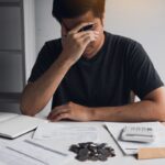 Asian men are stressed about financial problems, with invoices and calculators placed on the table while having stress on problems with home expenses. Asian men are stressed about financial problems, with invoices and calculators placed on the table while having stress on problems with home expenses.
