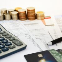 close up of a credit cards with credit card statements, pen, stack of coins and calculator on white background, financial concept, selective focus close up of a credit cards with credit card statements, pen, stack of coins and calculator on white background, financial concept, selective focus