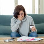 Upset young woman stressed about credit card debts and payments not happy accounting finances