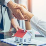 Real estate agent shakes hands with customer after finished contract after about home insurance and investment loan Real estate agent shakes hands with customer after finished contract after about home insurance and investment loan